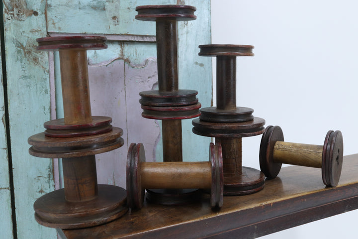Vintage wooden spinning bobbins with painted details